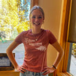 Load image into Gallery viewer, Smiling girl in a t-shirt that has two floral elements and "Kind Coffee Estes Park, Colorado" in the center