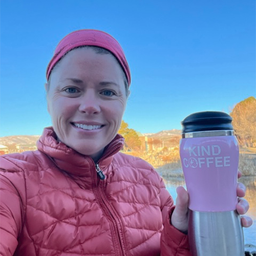a woman with her kind coffee travel cup in the mountains