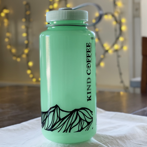 A single Nalgene, in a green glow in the dark color with mountain design along bottom. 
