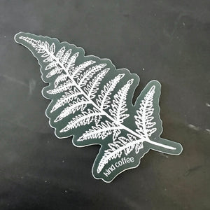 A sticker of a fern frond with a dark green background