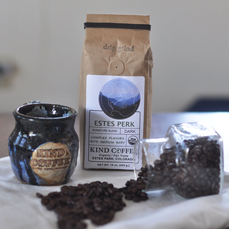 handmade kind coffee mug with one pound of coffee and spilled coffee beans on table