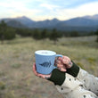 Load image into Gallery viewer, A light blue ceramic mug with a black fern graphic 
