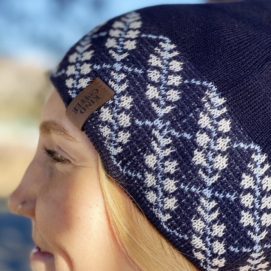 Side profile of blue beanie, with white patterning along the rim