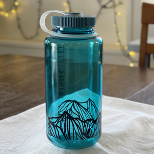 A single Nalgene, in the color cerulean with mountain design along bottom. 