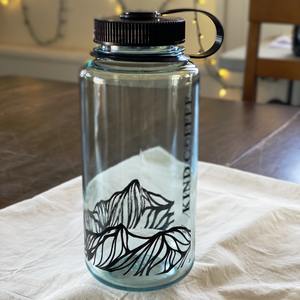 A single Nalgene, in a clear seafoam color with mountain design along bottom. 