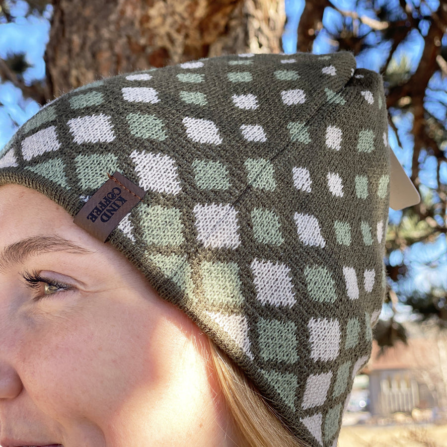 Side profile of green knit beanie with square geometric designs