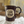 Load image into Gallery viewer, Brown ceramic mug with &quot;20 Years of Kind Coffee&quot; on a white cloth
