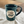 Load image into Gallery viewer, Dark teal ceramic mug with &quot;20 Years of Kind Coffee&quot; on a white cloth
