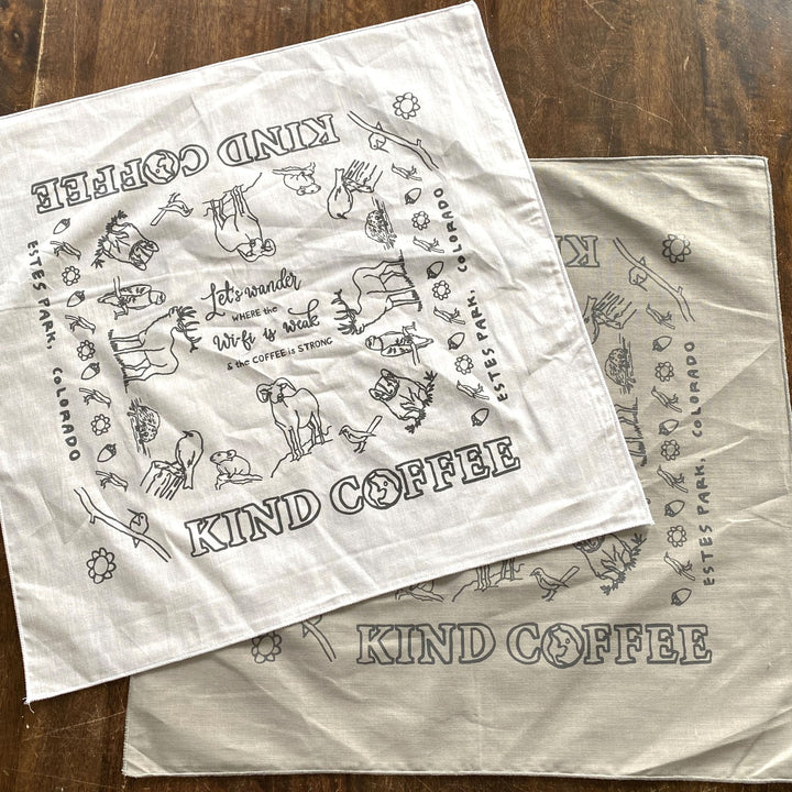 White and gray Let's Wander Bandanas. Design says "Let's wander where the Wifi is weak and the coffee is strong" in center with local animal sketches, and Kind Coffee - Estes Park, Colorado around the border. 