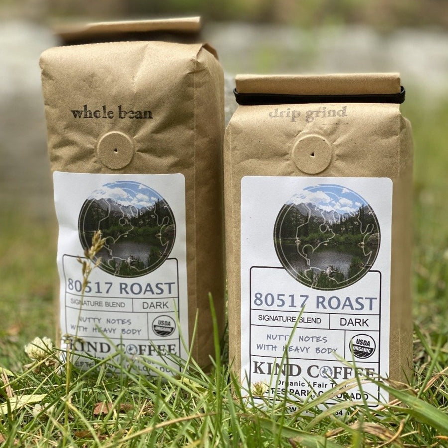 Two 1 lb bags of the 80517 Roast, one whole bean and one drip grind, sitting in the grass. 