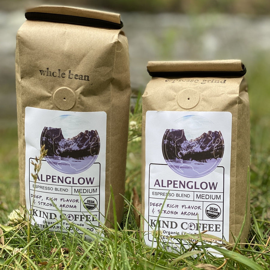 Two 1 lb bags of the Alpenglow roast, one whole bean and one espresso grind, sitting in the grass.