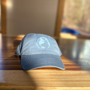 Navy Kind Coffee Globe Hat on a wooden counter