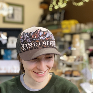 Barista wearing a Kind Coffee Mountain Trucker Hat